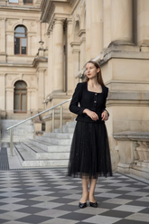 a lady in a black jacket and a tulle sequin skirt